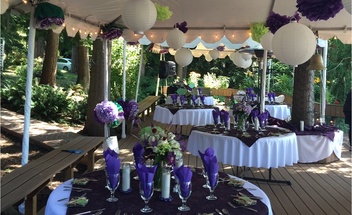 A table with purple and white decorations on it.