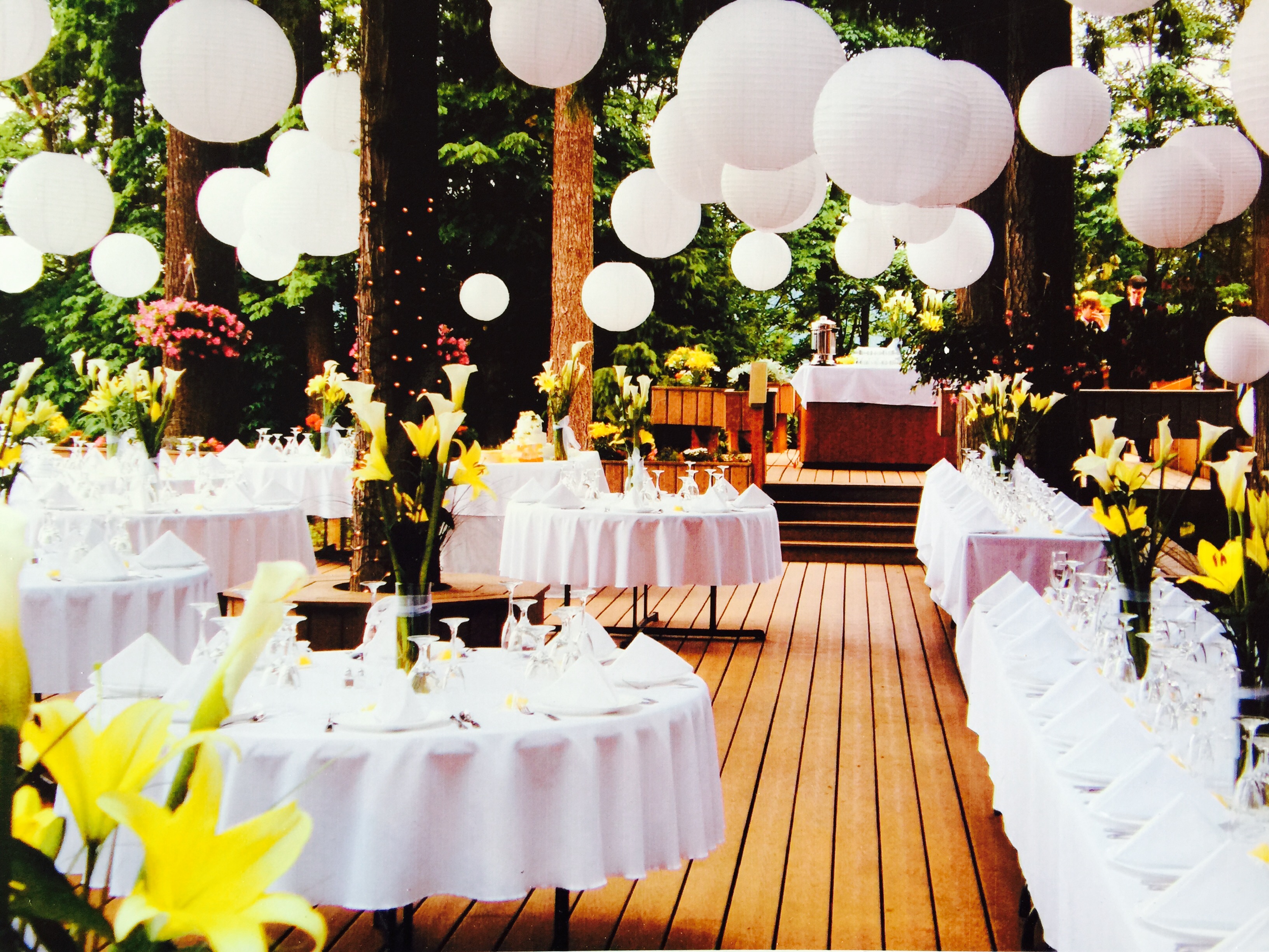 A wedding reception with white tables and paper lanterns.