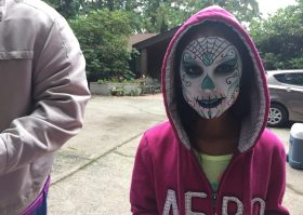 A girl with a face paint on her head.