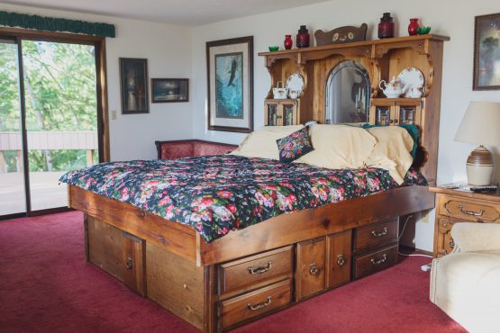 A bed with drawers and a floral comforter.