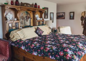 A bed with floral comforter and pillows in a room.