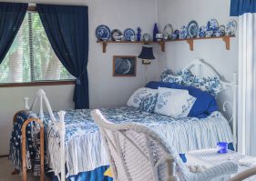 A bedroom with blue and white decor in it